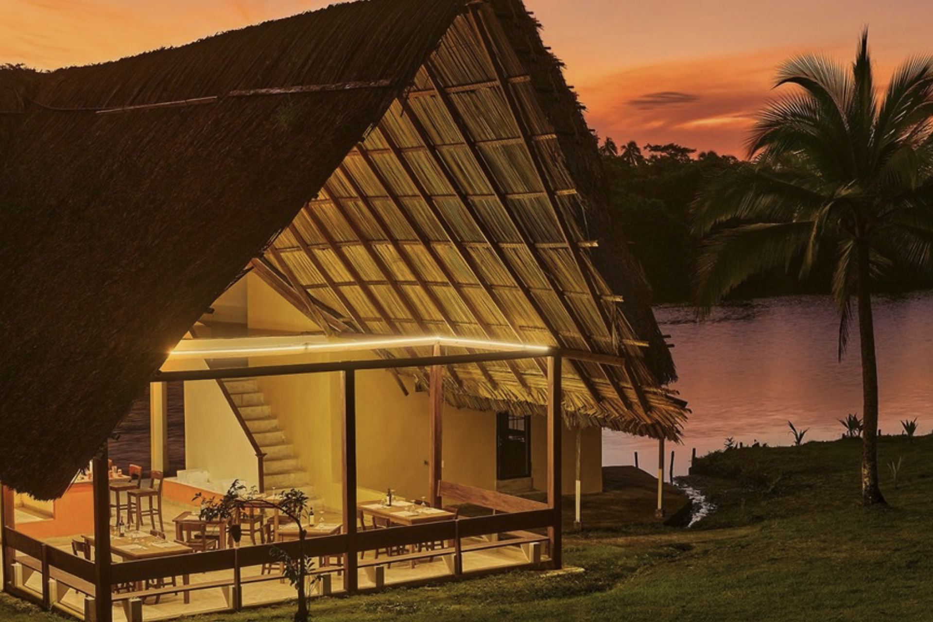 Restaurant der Rainforest Lodge bei Sonnenuntergang an der Lagune